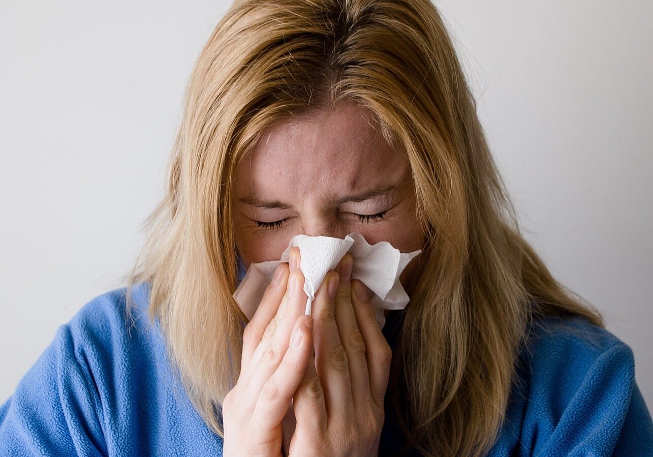 A stock image of a woman sneezing to illustrate effects of allergic rhinitis